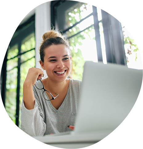 Woman smiling while sitting at a desk with a laptop