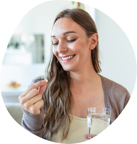 Smiling woman about to take a pill