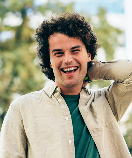 Young man laughing outdoors
