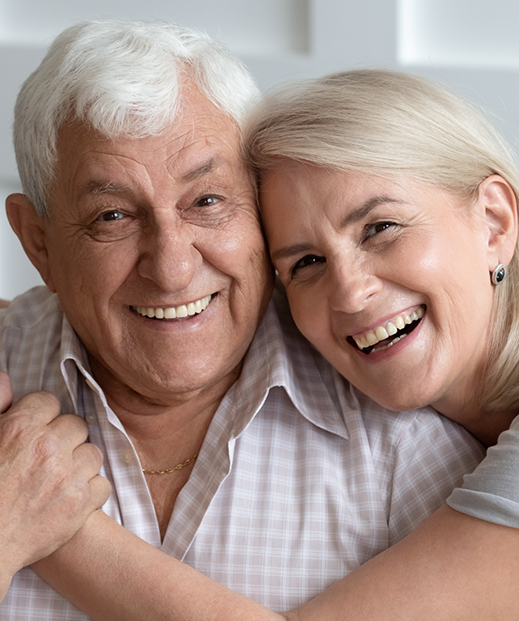 Senior couple grinning and embracing after receiving psychiatric care in Austin