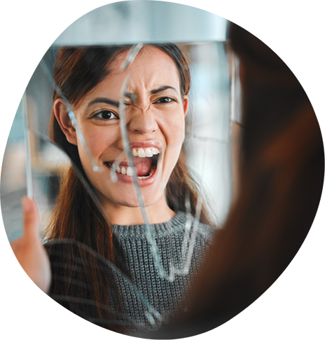 Woman screaming in front of a broken mirror