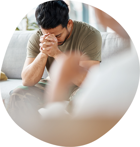 Man closing his eyes and holding his fists in front of his face while talking to his psychiatrist